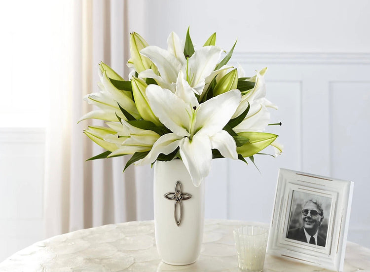 The symbolic white lily shares meaningful messages with your loved ones during times of joy as well as times of sadness. Our Faithful Blessings™ bouquet features a gorgeous cross adorned vase that is full of breathtaking blooms. 