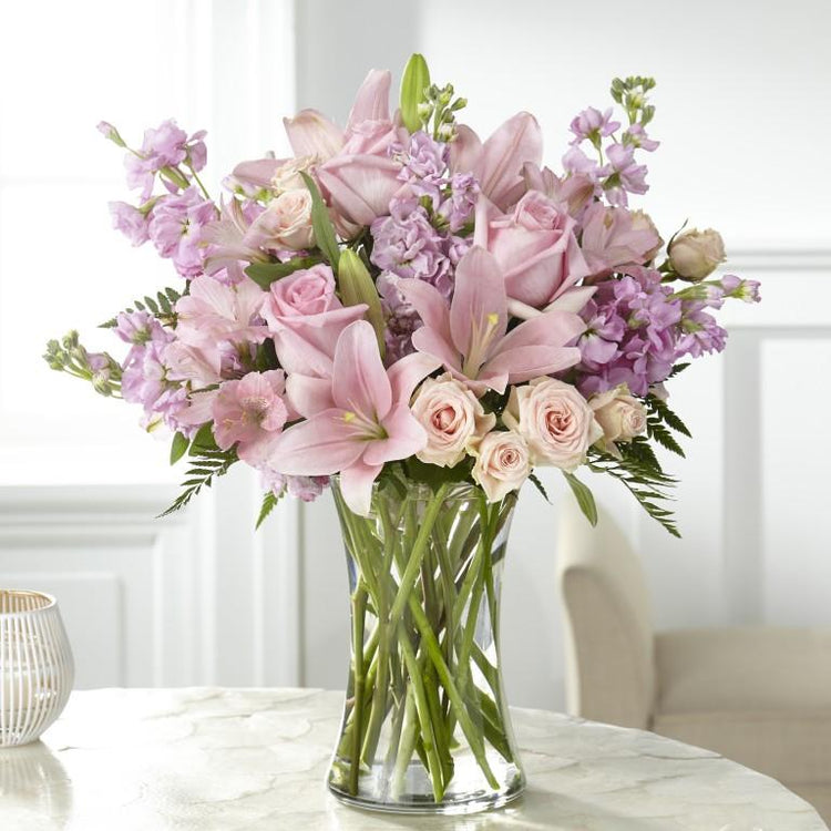 An array of blushing pink blooms come together beautifully to express your condolences in our Wishes & Blessings Bouquet. Each bloom is designed to share sympathies and bring comfort to those experiencing sadness during a time of loss. light pinks and lavender flowers. standard size